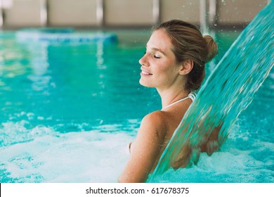 Beautiful woman enjoying jet of water in spa  resort