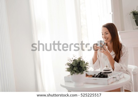Beautiful woman enjoying morning tea wearing shirt