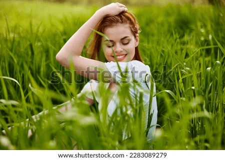 beautiful woman enjoying nature sitting in tall grass