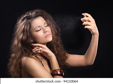 Beautiful woman enjoying a perfume on black background