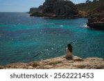  Beautiful woman enjoying the serene Jelly Sea in Mallorca, Spain during a sunny day
                              