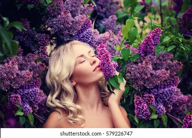 Beautiful Woman Enjoying The Smell Of Lilac. Cute Model And Flowers. Aromatherapy And Spring Concept