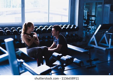 Beautiful woman is exercising and fitness. The trainer gives instructions on how to exercise in the gym