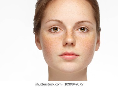 Beautiful woman face close up with freckles isolated, cleam skin