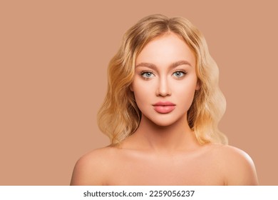 Beautiful Woman Face close up studio on peach background. Makeup. Beauty Portrait of female Face with smokey eyes and arrows, beautiful natural plump lips. Isolated                     