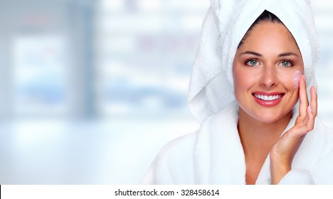 Beautiful woman face with moisturising cream. Skin care background.