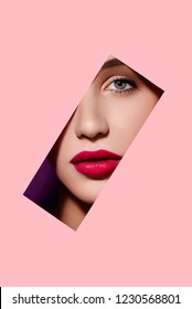 Beautiful woman face in pink paper frame. Plump red lips, blue eyes and clear skin. Fashion and beauty, close up portrait