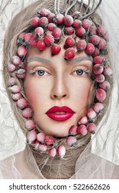 Beautiful Woman Face With Professional Makeup, Frosty Winter Beauty. Close Up Portrait. Surrounded By Red Berries