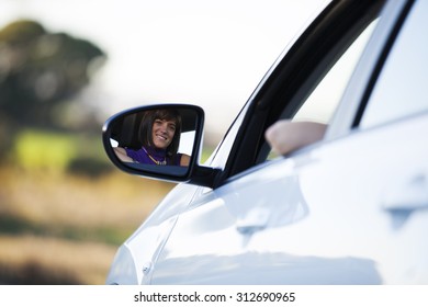 Beautiful Woman Face Reflected On The Side Mirror Of Her New Car