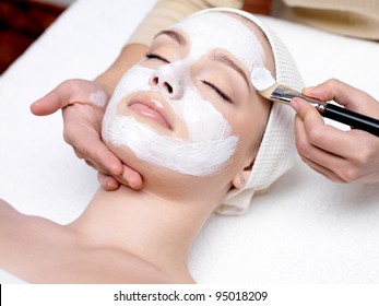 Beautiful woman with facial mask at beauty salon