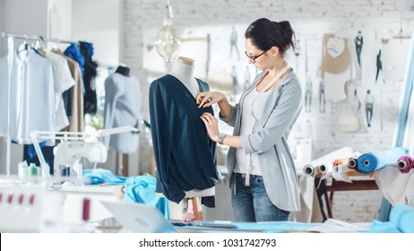 Beautiful Woman fashion, designer,  Working with Tailoring Mannequin, Adjusting Blouse. Her Studio is Bright and Sunny, Mannequins Standing around, Clothes Hanging, Colorful Fabrics Lying on the Table - Powered by Shutterstock