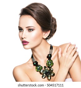 Beautiful woman with fashionable jewelry.  Portrait of a pretty fashion girl with green glass necklace. American Model posing over white background