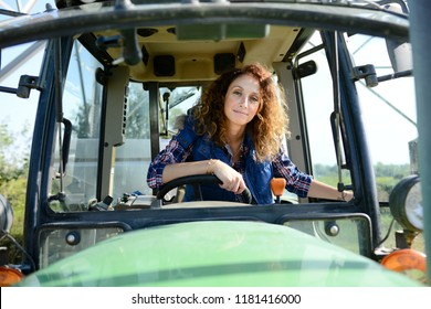 beautiful woman female farmer driving tractor in countryside field - Powered by Shutterstock