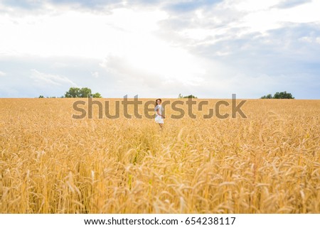 Similar – Woman alone in a field of wheat