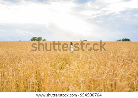 Similar – Woman alone in a field of wheat