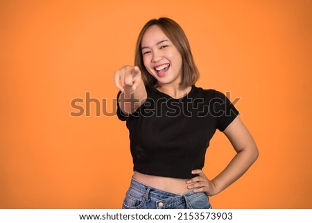 beautiful woman with finger pointing at frong and laughing at something isolated background