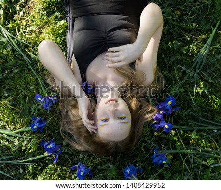 Similar – Frau in einem Blumenfeld bedeckt sich vor Sonnenlicht.