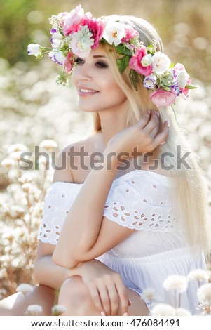 Beautiful woman with flower wreath. Young beautiful woman walking outdoors at summer.  beautiful woman with a wreath of flowers in summer field