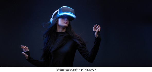 Beautiful woman with flowing hair over dark background. Girl in glasses of virtual reality. Augmented reality, science, future technology, robots and people concept. VR. - Powered by Shutterstock