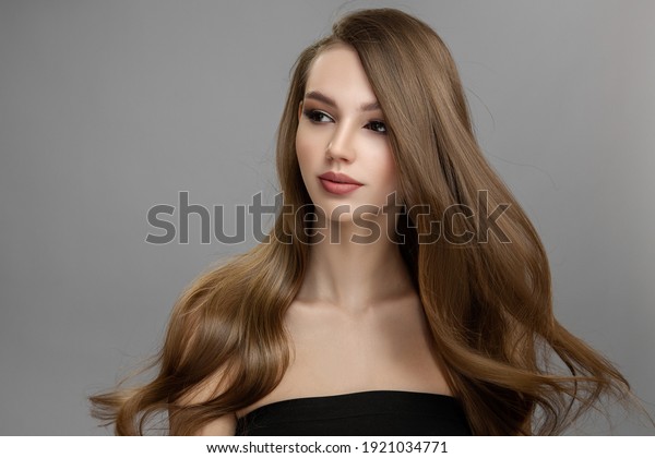 Beautiful woman with flying hair. Long hair\
hairstyle and makeup