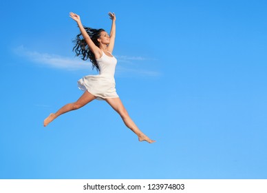 Beautiful woman flying in jump against blue sky - Powered by Shutterstock