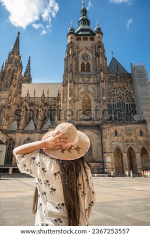 A beautiful woman in front of St. Vitus Cathedral at Prague Castle in Prague under Clear Blue Sky Sunny Summer. Full of Tourist people