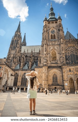 A beautiful woman in front of St. Vitus Cathedral at Prague Castle in Prague under Clear Blue Sky Sunny Summer. Full of Tourist people