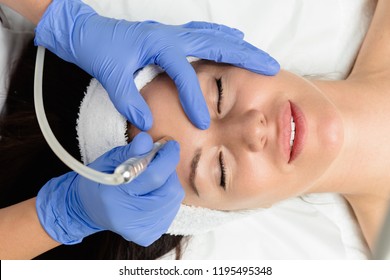 Beautiful woman getting facial microdermabrasion peeling treatment at luxury cosmetic beauty spa clinic. Exfoliation, rejuvenation and hydratation. Cosmetology concept. 