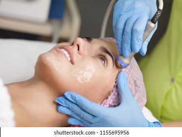 Beautiful Woman Getting Radio Frequency Lifting On Her Face. Professional Beautician Doing Anti-wrinkle Facial Treatment. Concept Of Skin Care And Correction Of Skin Texture.