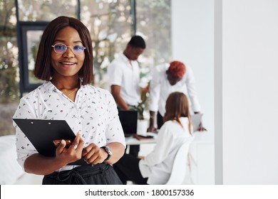 Beautiful Woman In Glasses In Front Of Her Colleagues. Group Of African American Business People Working In Office Together.