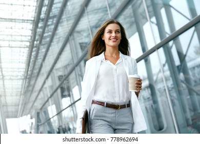 Beautiful Woman Going To Work With Coffee Walking Near Office Building. Portrait Of Successful Business Woman Holding Cup Of Hot Drink In Hand On Her Way To Work On City Street. High Resolution. - Shutterstock ID 778962694