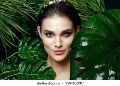 Beautiful woman green leaves make-up jungle lifestyle exotic vacation