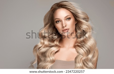 beautiful woman  hair coloring in ultra blond. Stylish  girl hairstyle curls done in a beauty salon. Fashion, cosmetics and makeup.