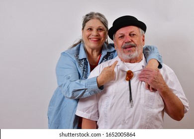 Beautiful Woman And Handcome Old Man Smiling And Holding Hands While Facing The Camera.