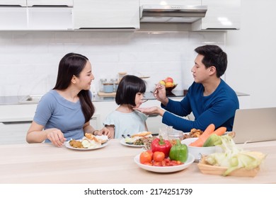 Beautiful Woman Handsome Man And Lovely Asian Girls Are Eating On The Kitchen Table At Home. Everyone Is Happy. It's A New Normal Life For The Family.