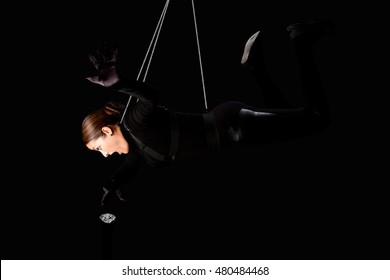 Beautiful Woman Hanging From Wire Cables Stealing A Diamond, Jewelry Heist Crime Concept.