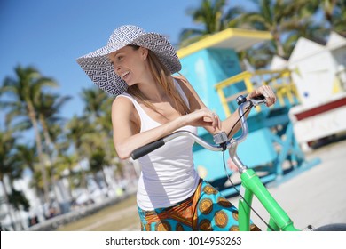 Beautiful Woman With Hat Riding Bike In Miami Beach