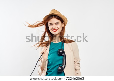 beautiful woman in a hat smiling holding a wire-line on a light background                               