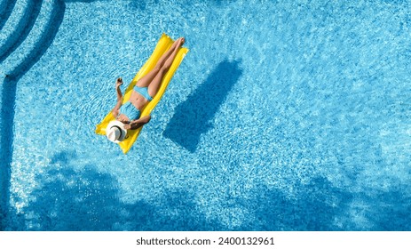 Beautiful woman in hat in swimming pool aerial drone view from above, young girl in bikini relaxes and swims on inflatable mattress and has fun in water on vacation, tropical holiday resort - Powered by Shutterstock