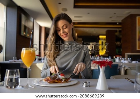 Beautiful woman having breakfast alone in the restaurant