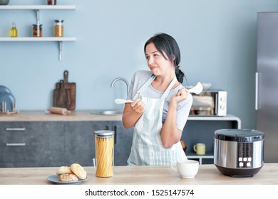 Beautiful woman having fun while cooking in kitchen