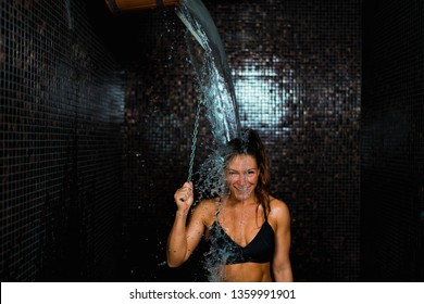 Beautiful Woman Having an Ice Cold Shower Bucket after Sauna.