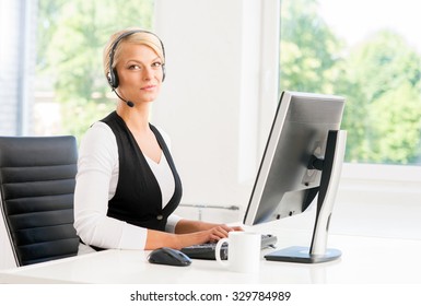 Schöne Frau im Headset, die im Callcenter arbeitet.