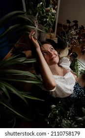 Beautiful Woman And Her Cat With A Lot Of House Plants At Home.