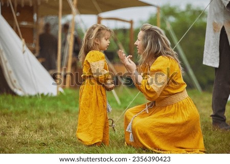 Beautiful woman with her daughter dressed in embroidered dresses