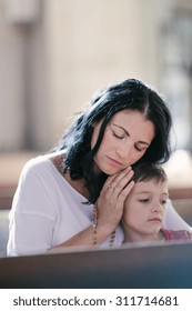 Beautiful Woman With Her Son Praying In The Church