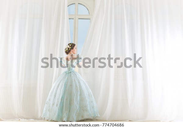 Beautiful woman in historical fashion dress in the big\
hall 
