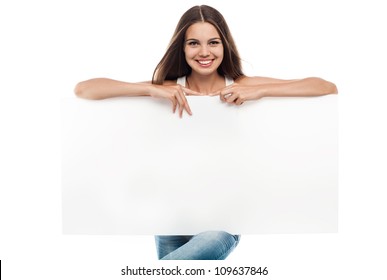 Beautiful woman holding a blank billboard isolated on white background
