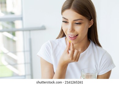 Beautiful Woman Holding Fish Oil Pill In Hand