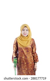 Beautiful woman holding pelita or oil lamp standing on isolated white background, Feast of Aidilfitri concept